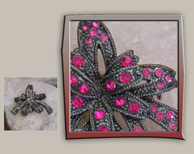 Festive vintage brooch of ribbon bow in textured metal covered with pink crystals