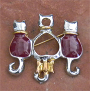 Cat lover brooch-Three cats sit together in gold and shiny silver metal with burgundy enamel. 