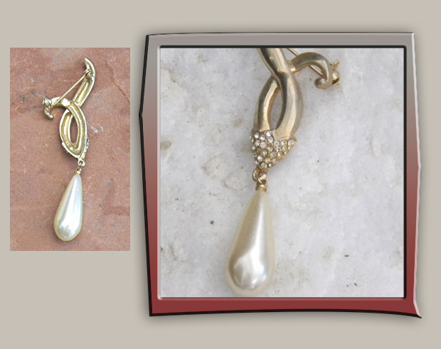 Vintage brooch features long pearl droplet on gold metal sash