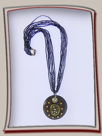 wooden pendant adorned with metal art and crystals