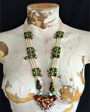 ornate beaded necklace has etnic feel...red and green.